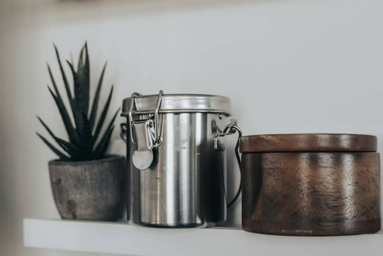 Stainless-steel tiffin carrier with a latch lid on a clean white shelf